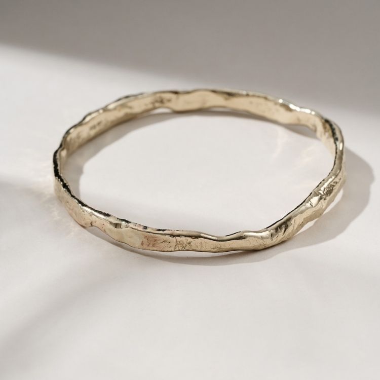 A Luna Textured Gold Bangle from Lulu and Boo Jewellery.
