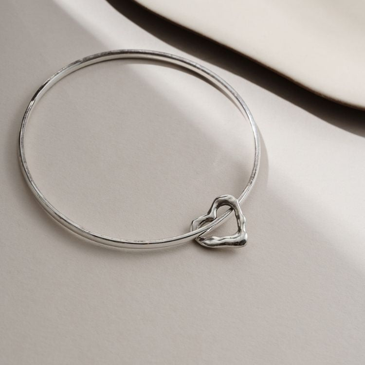 A Molten Heart Sterling Silver Charm Bangle from Lulu and Boo Jewellery.