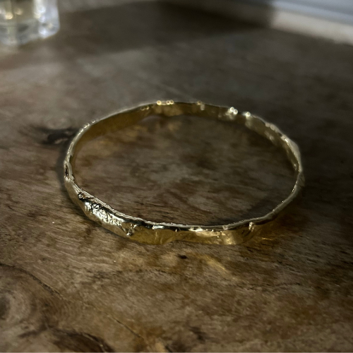 A Luna Textured Gold Bangle from Lulu and Boo Jewellery.
