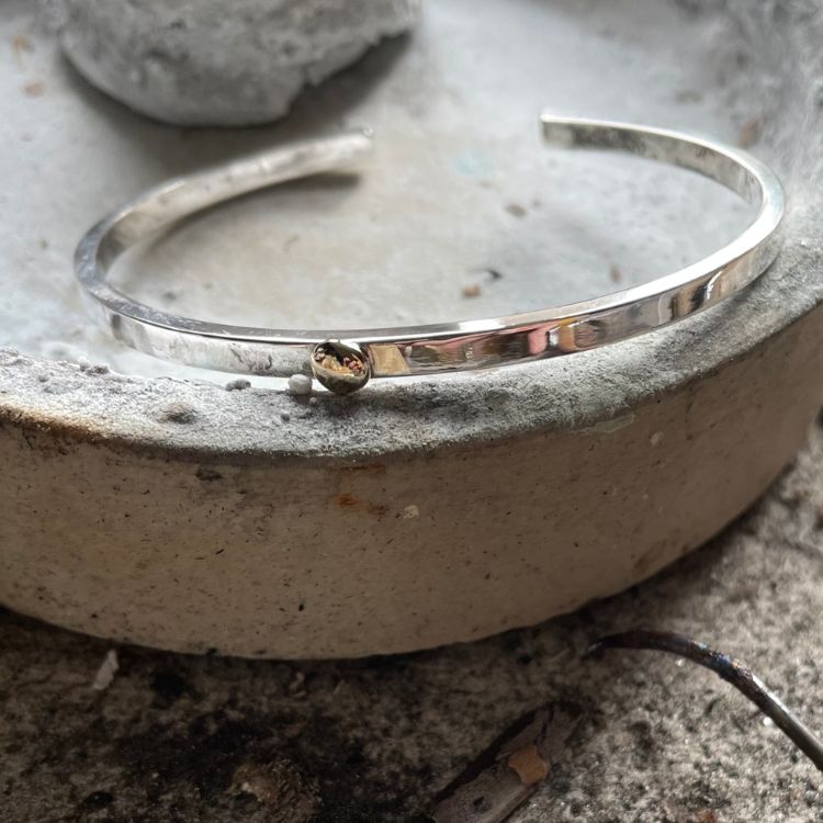 Dainty silver cuff bangle with gold bobble.